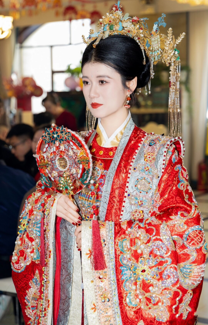 嫁衣采用传统的红色,寓意着吉祥如意,上面绣着精美的龙凤图案,展现出