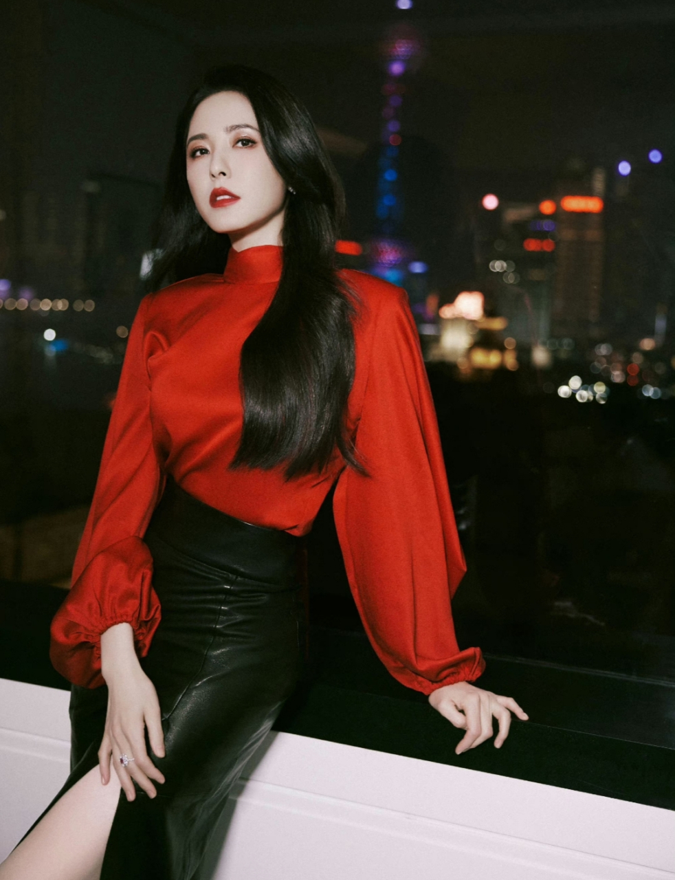 曾黎身穿大红色上衣搭配黑色开叉皮裙,五官分明,眼睛深邃迷人,尽显