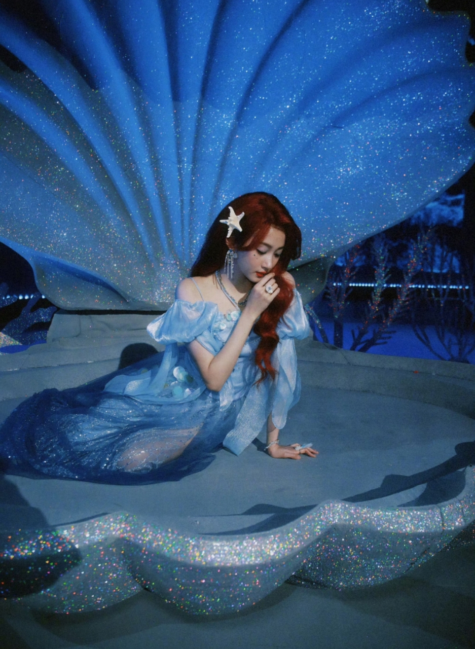 关晓彤一袭蓝色一字肩纱裙,造型精美,一头枣红色的微卷发型散落,在