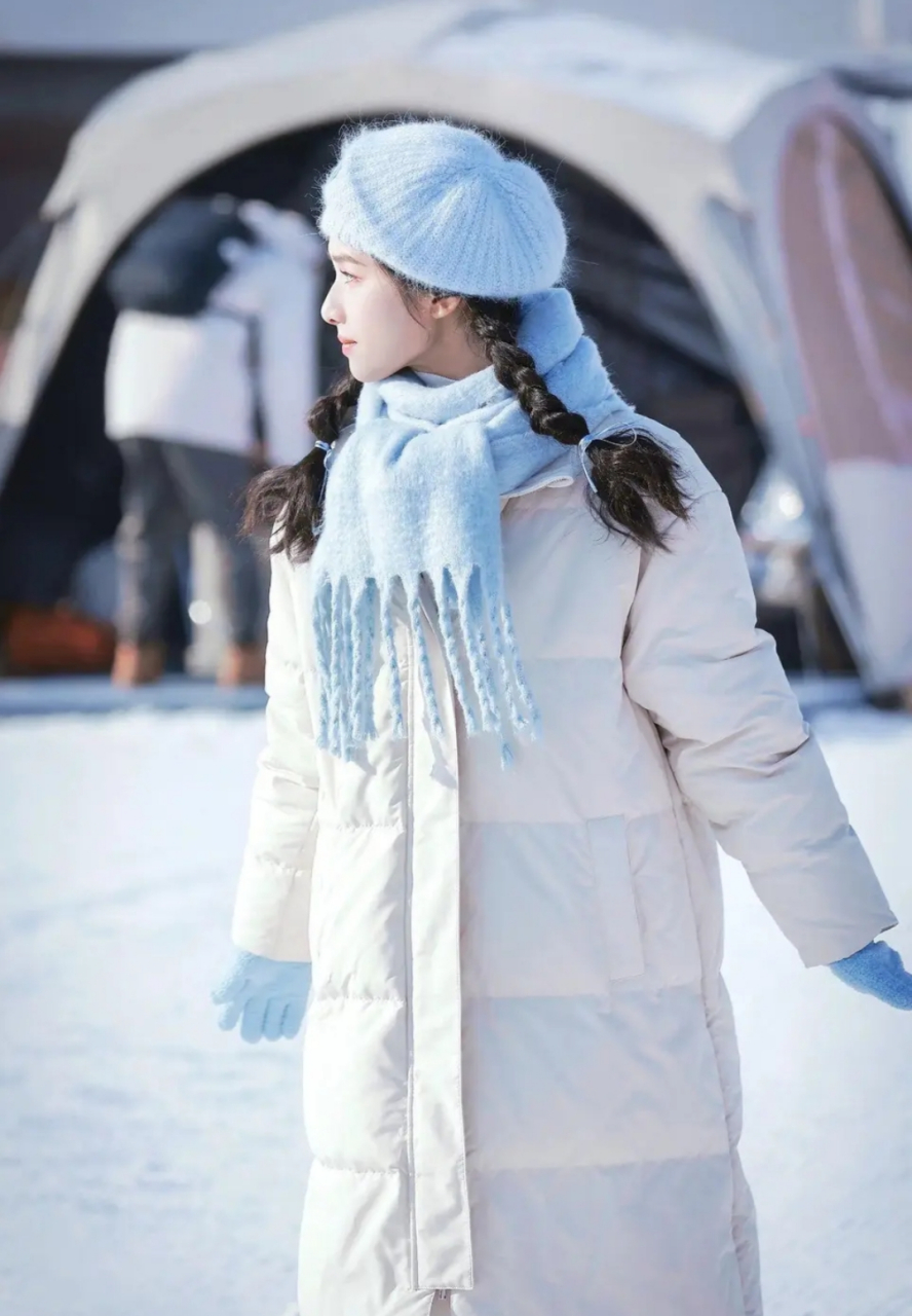 张婧仪在雪地里身穿白色羽绒服戴贝雷帽,搭配两个麻花辫软萌俏皮,如