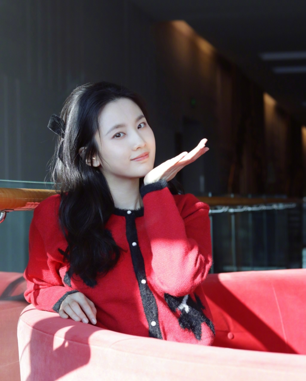张慧雯身穿红色针织衫,头戴黑色蝴蝶结微卷发型随意披散,活泼可爱