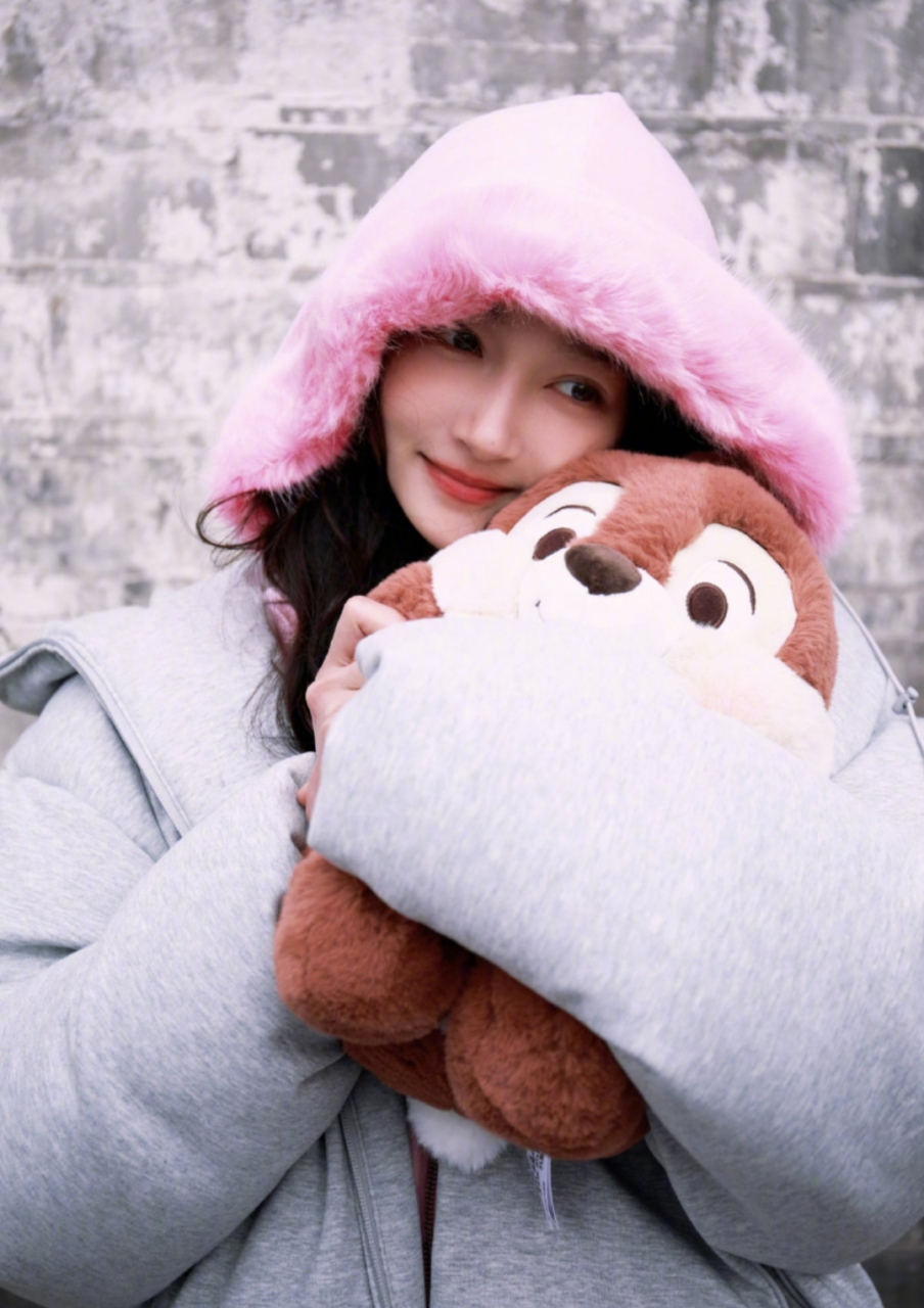 关晓彤灰色羽绒服的穿搭,头戴粉色帽子,可爱温柔,灵气逼人.