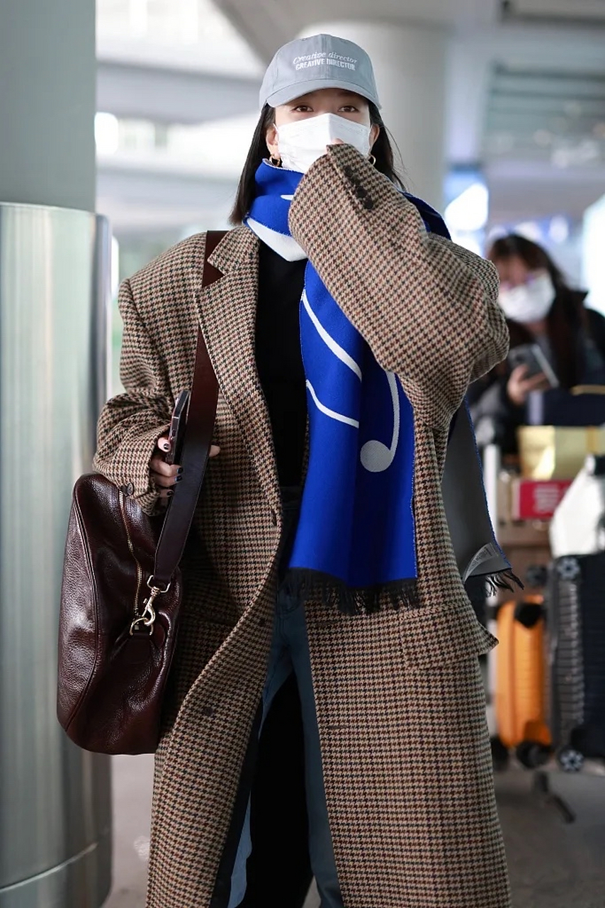 宋妍霏机场街拍来了,她戴了一顶白色棒球帽,穿一件驼色小格子长款大衣