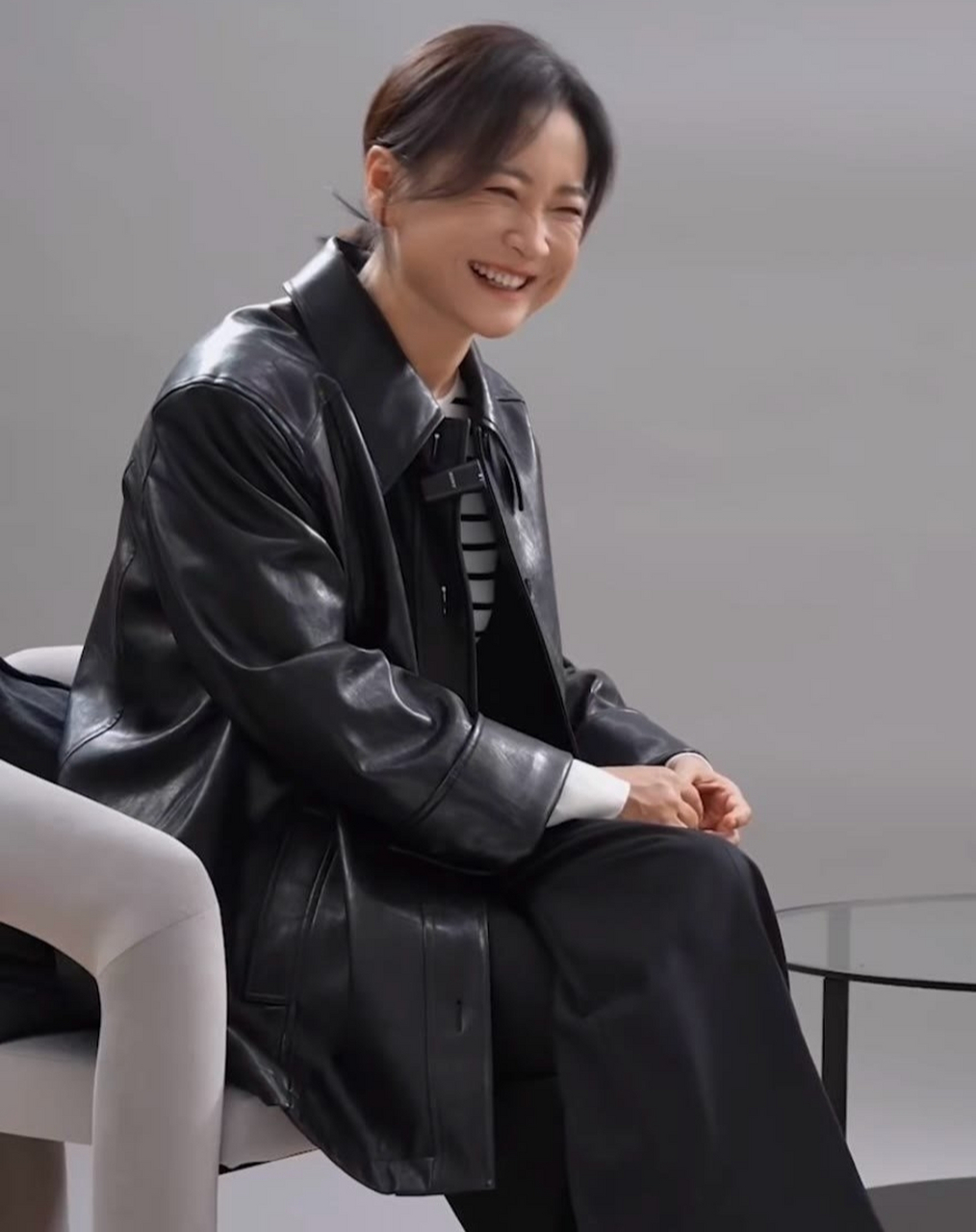 瘦身成功的贾玲,身穿黑色皮衣搭配黑白条纹毛衫,笑容可掬,美的仿佛换