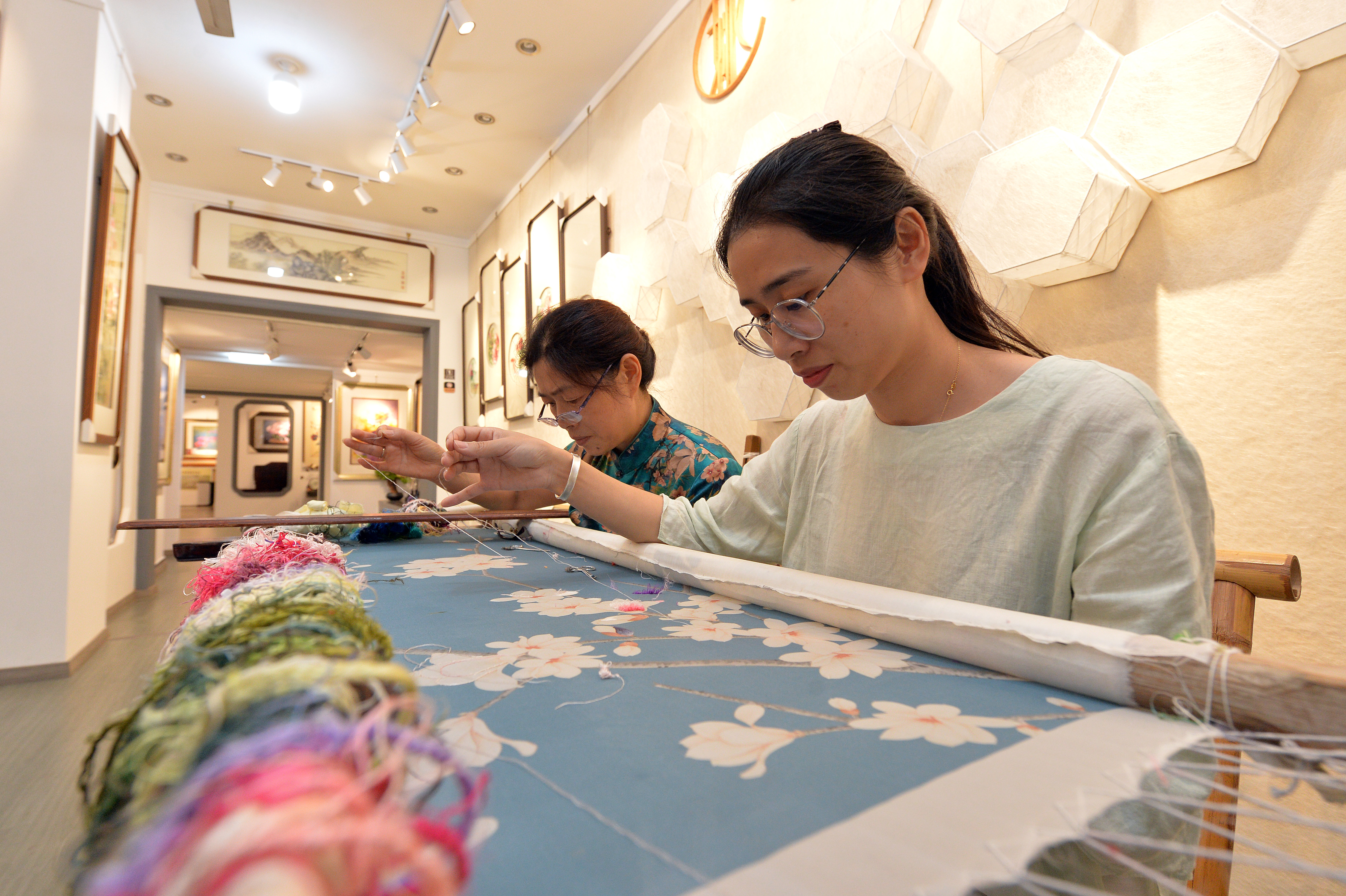 看苏州绣娘,把蚕辛辛苦苦吐出的丝,辛辛苦苦缫出,默默织成世上的羽衣.