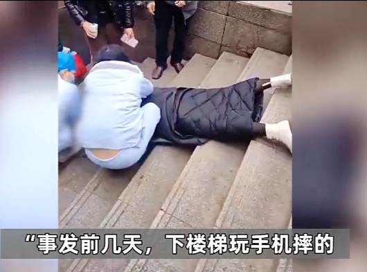 四川自贡一女子边下楼梯边玩手机,不慎从楼梯上摔了下来,看样子人是摔