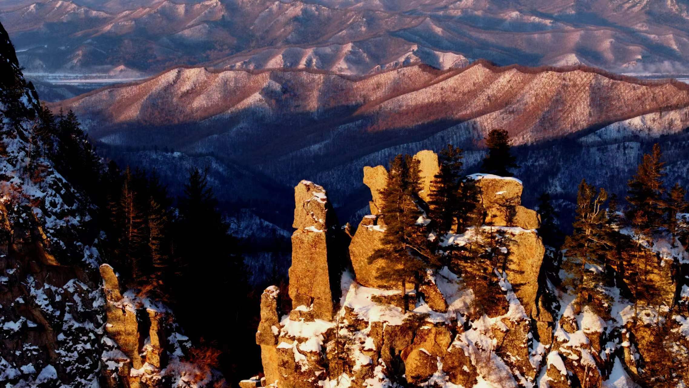 伊春九峰山养心谷雪景如画,白雪覆盖的山峰和小径如诗如画,阳光下的