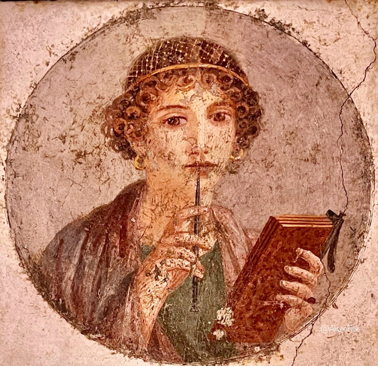 这幅美丽的罗马画描绘了一位妇女拿着一块书写板,一支书写笔举到唇边