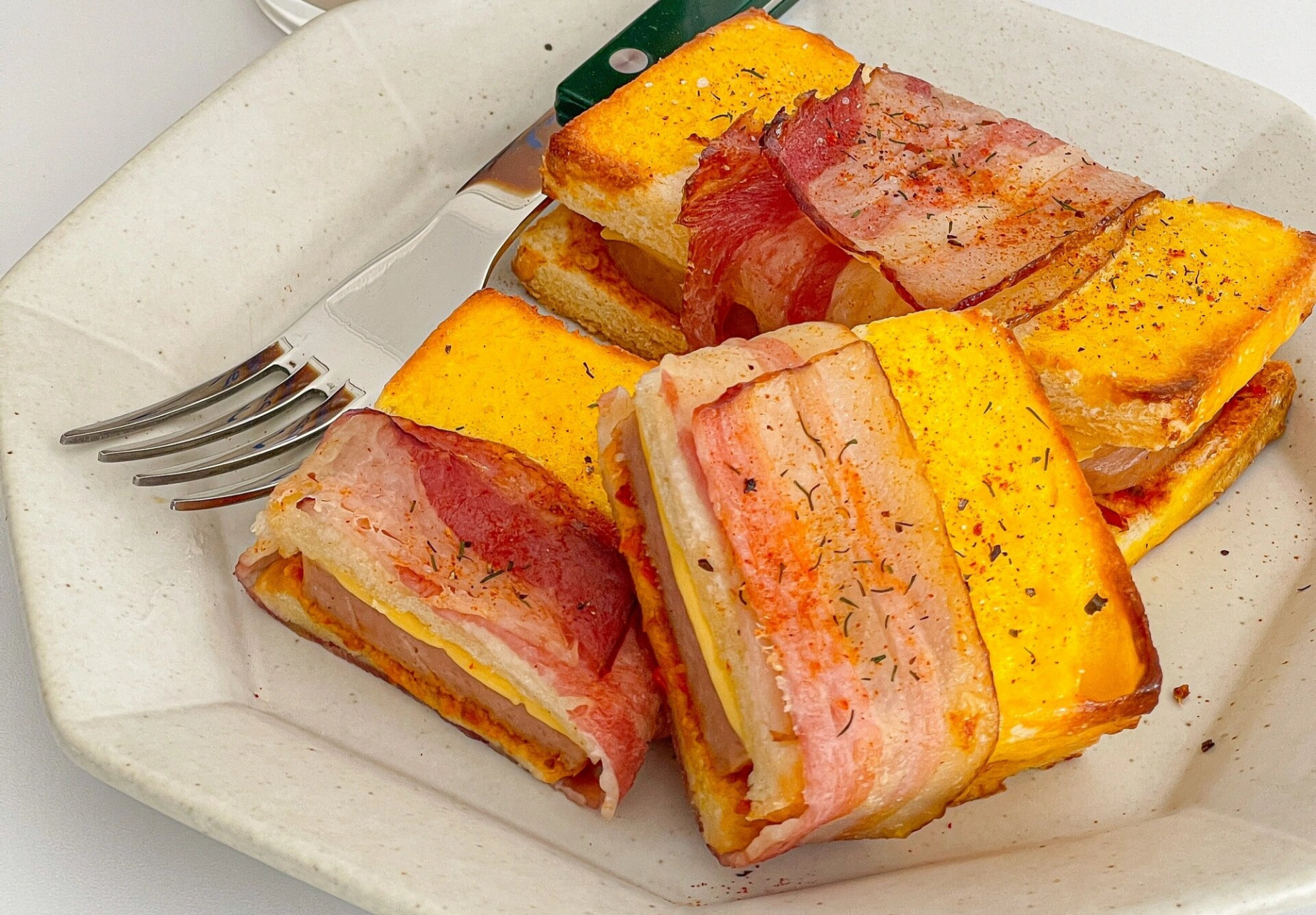 午餐肉芝士培根吐司卷07 吐司去边切开 涂抹番茄酱(我爱吃咸口 涂的