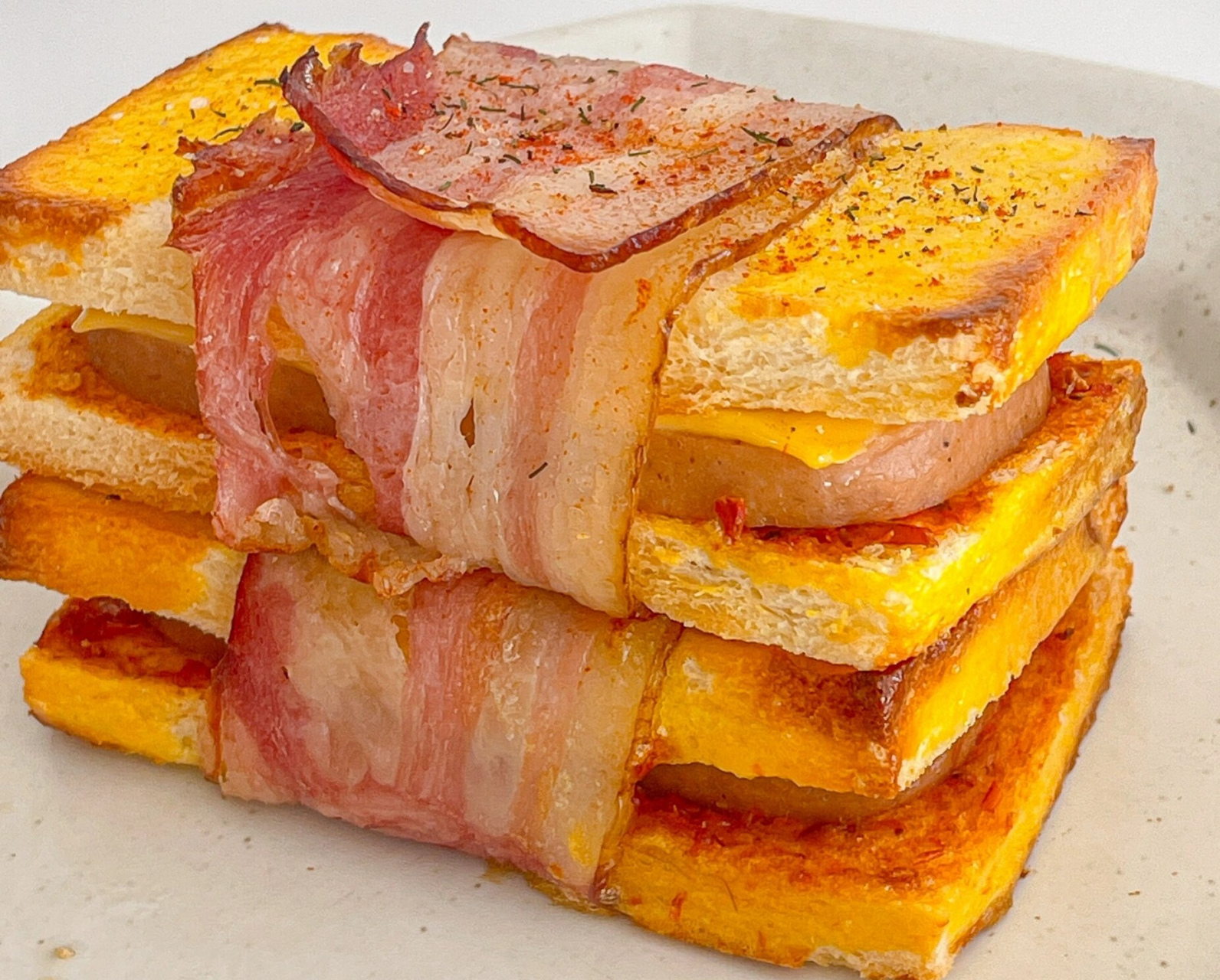 午餐肉芝士培根吐司卷07 吐司去边切开 涂抹番茄酱(我爱吃咸口 涂的