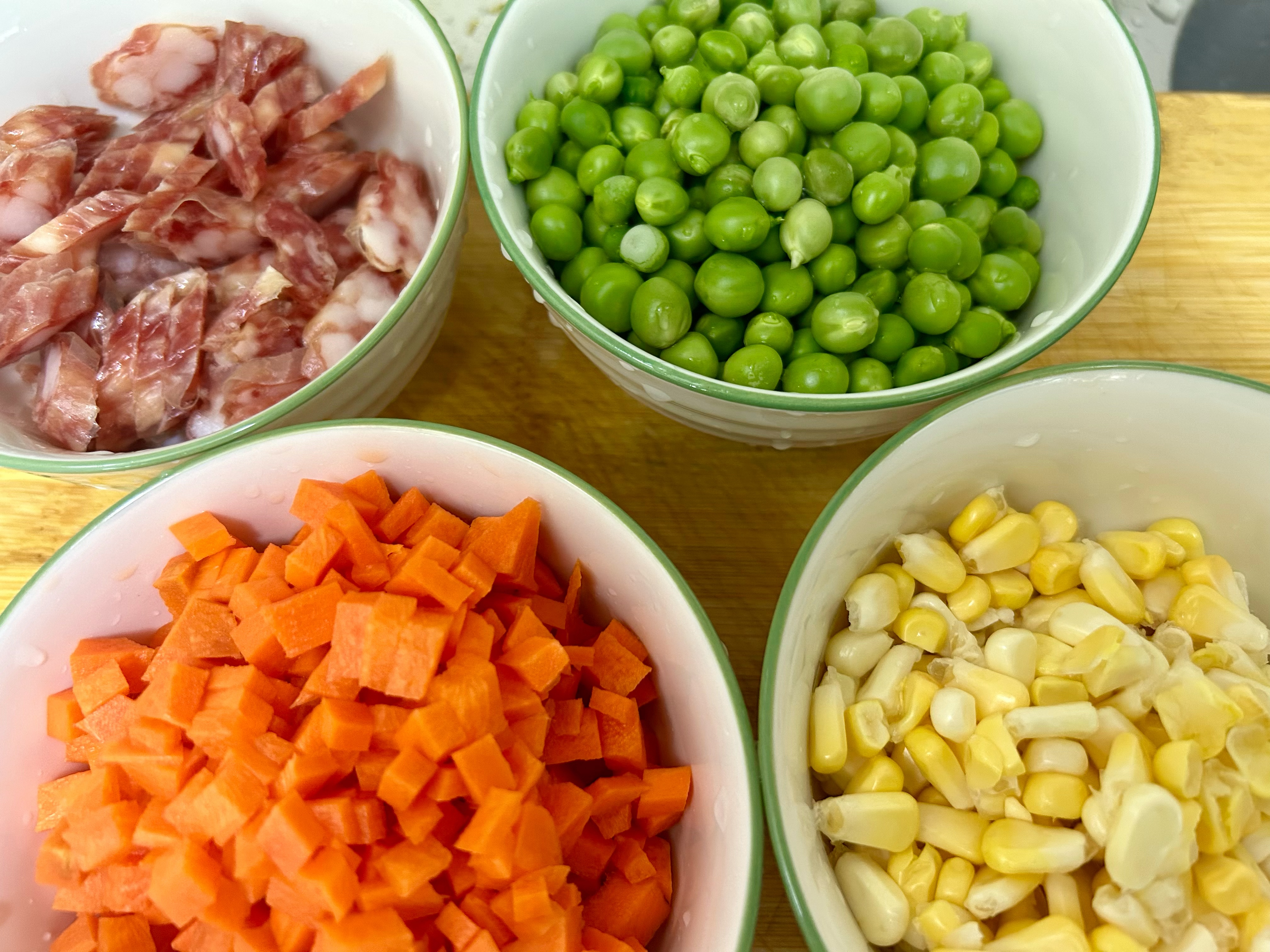 自己在家做的煲仔饭,准备好青豆,红萝卜丁,玉米粒,香肠,先在油锅里炒