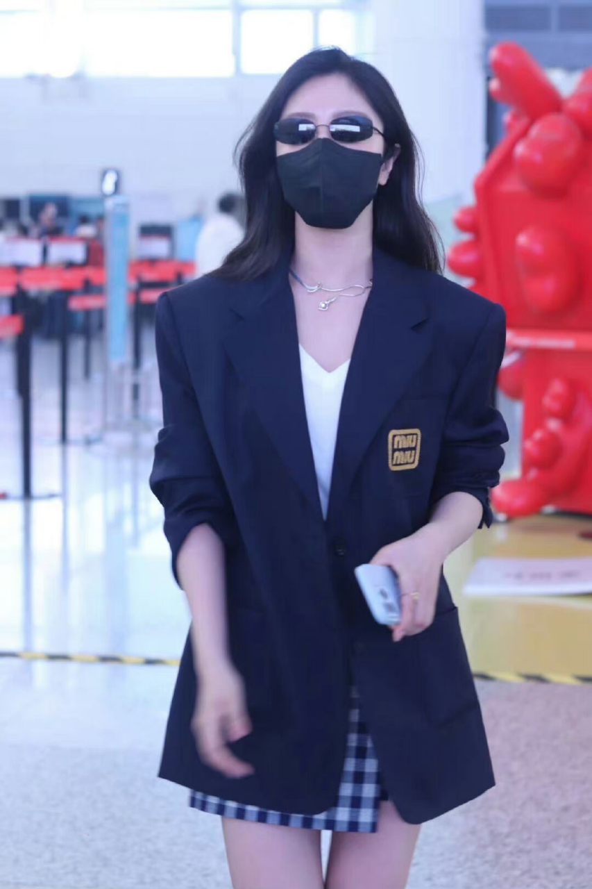 西装加墨镜和黑色口罩,有点霸道总裁的范儿,摘下口罩露出甜甜的腥容