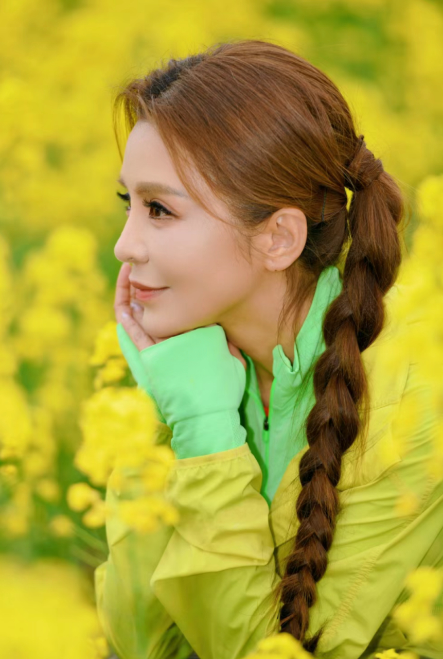 朱迅在成都一油菜花丛里拍摄美照,两个麻花辫好有特色,她的发量真让人