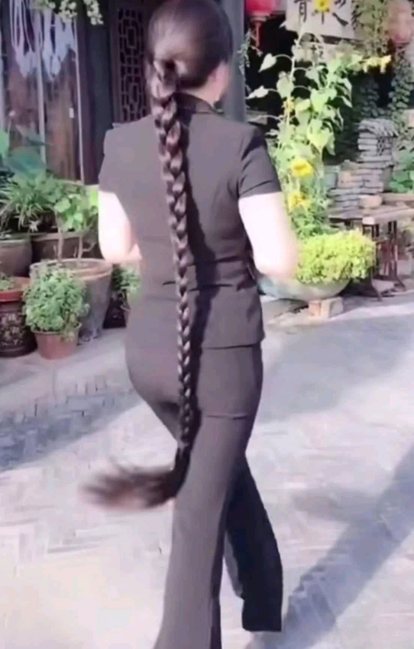 她身材窈窕,步伐矫健,脑后一条粗又长的大辫子,走起路来左右摇摆,气质