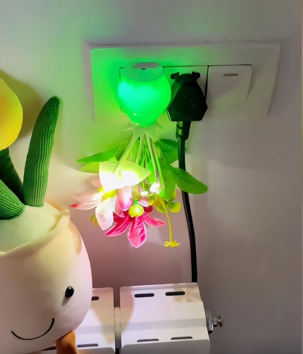 在关灯之后,这个小夜灯果然是亮起来了,但是它的花瓶是绿色的,叶子是