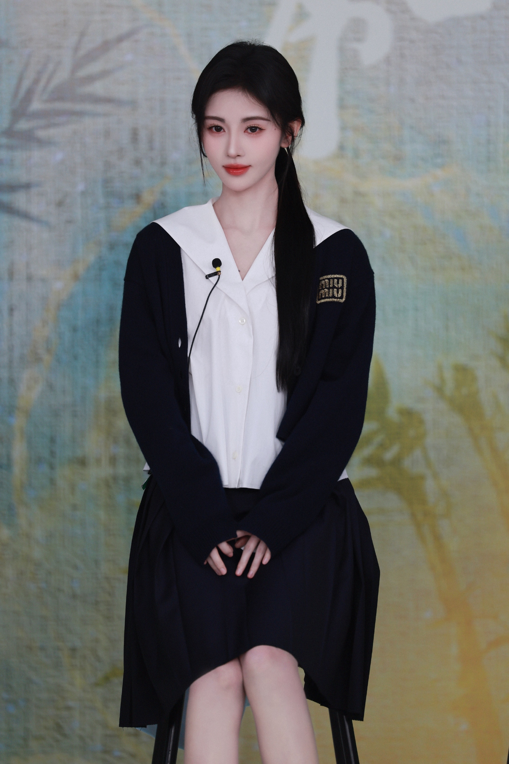 鞠婧祎穿一件黑色的短款针织开衫,内搭一件海军领衬衫,搭配一条黑色的