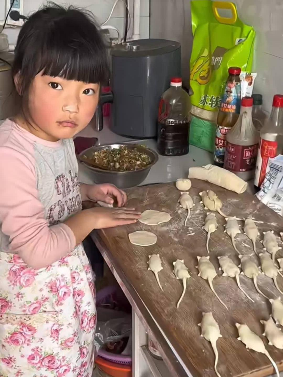 瞧这位小女孩头发俏皮地扎成两个小辫子脸上专注的表情仿佛在 