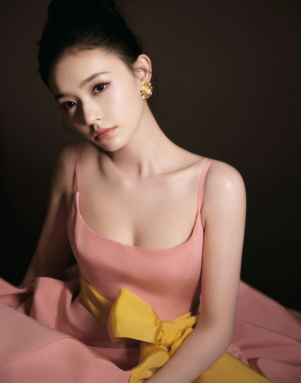 林允身着粉色吊带裙,身材凹凸有致,头发利落盘起,简单利落,温暖柔和.