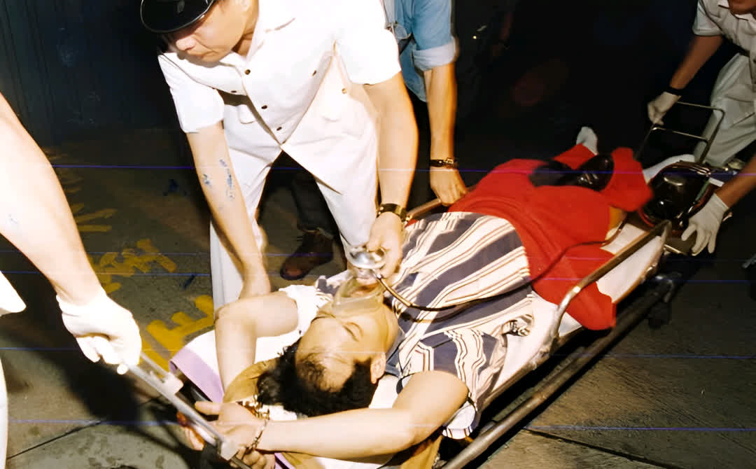 照片中,他躺在担架上,腿部中弹