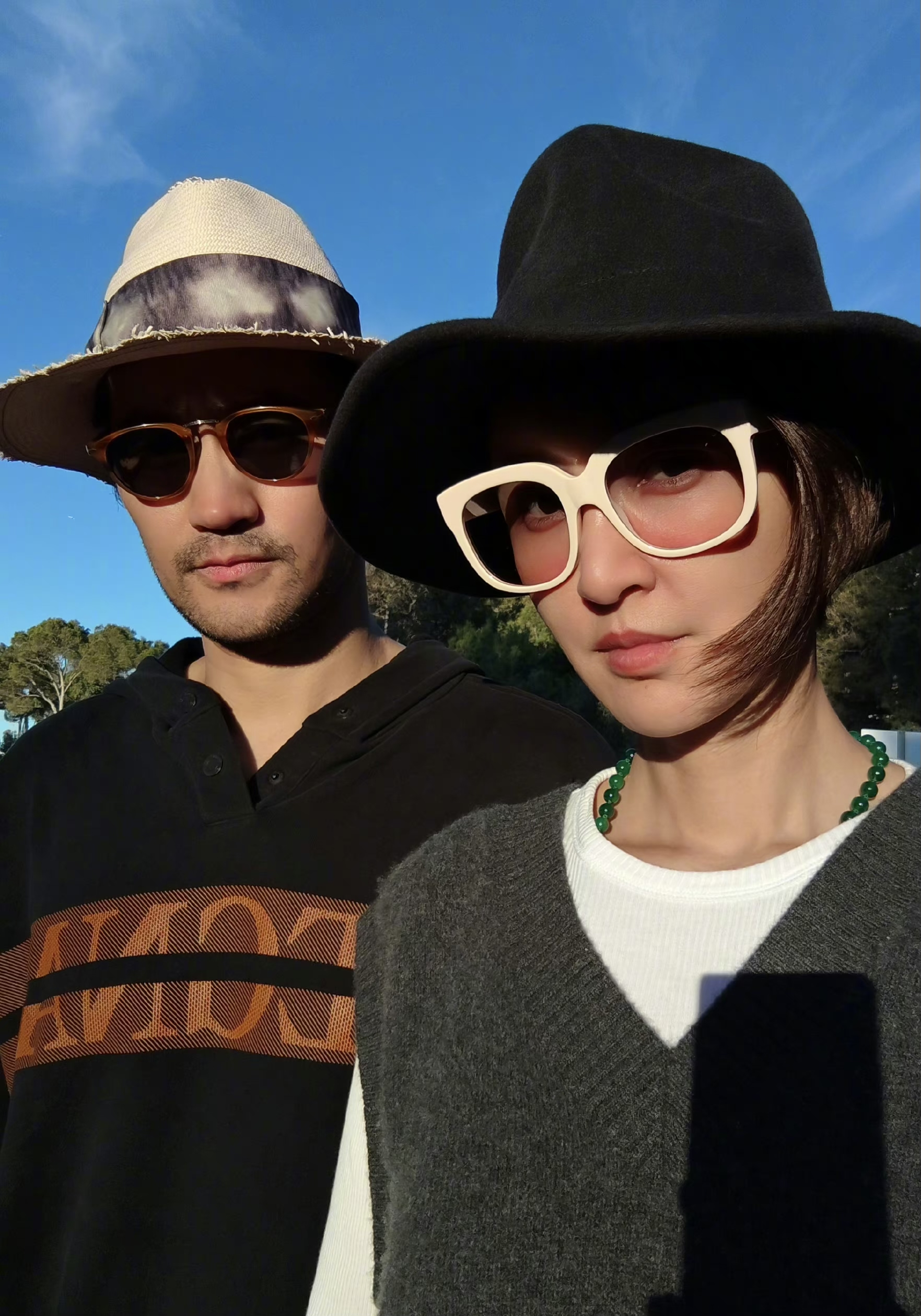 照片中,袁弘张歆艺均是深色系穿搭并搭配