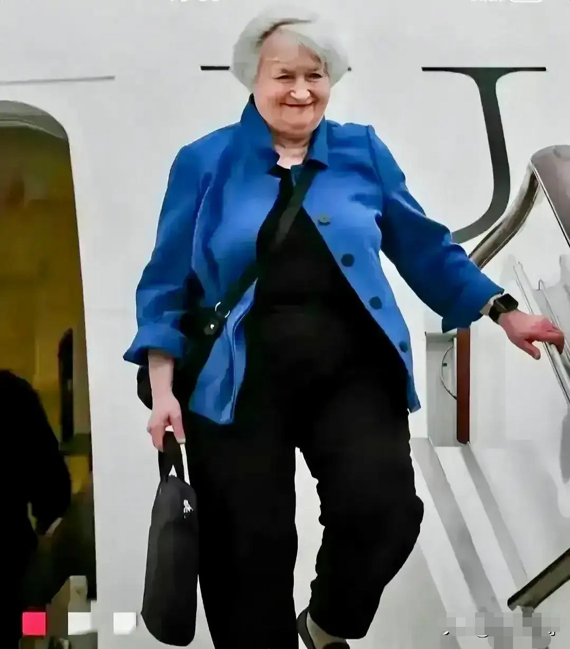 擦亮眼睛,对比一下耶伦的前后两张照片  耶伦刚下飞机时斜挎一个书包