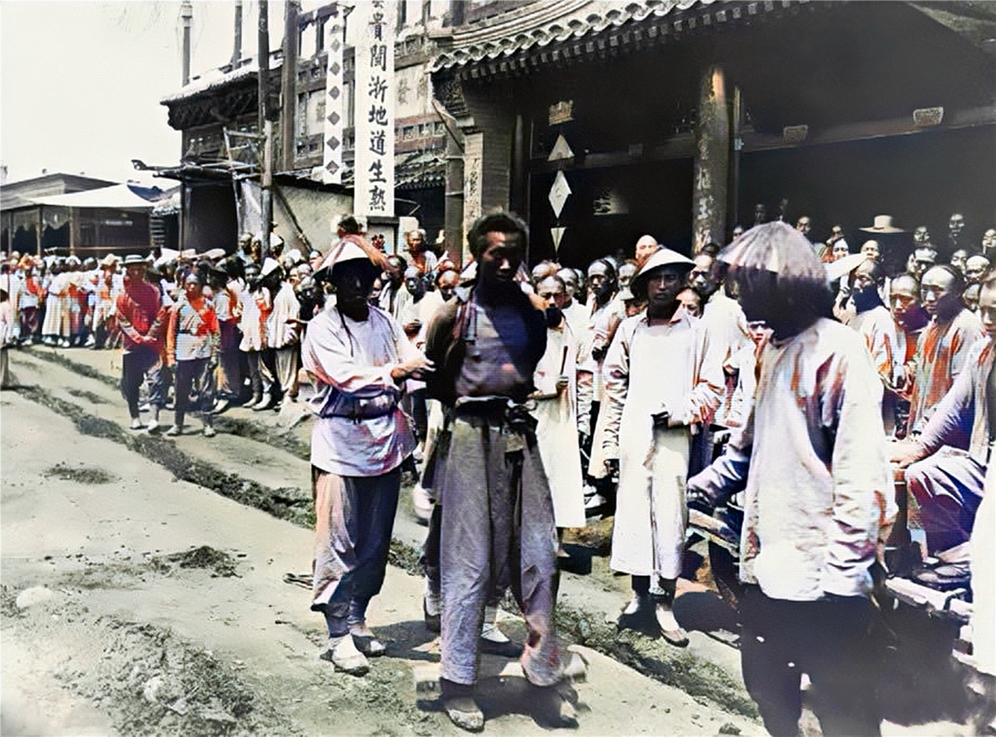 不堪的罪犯,双脚戴着镣铐,双手被反绑,正由一群衙役将其押往刑场斩首