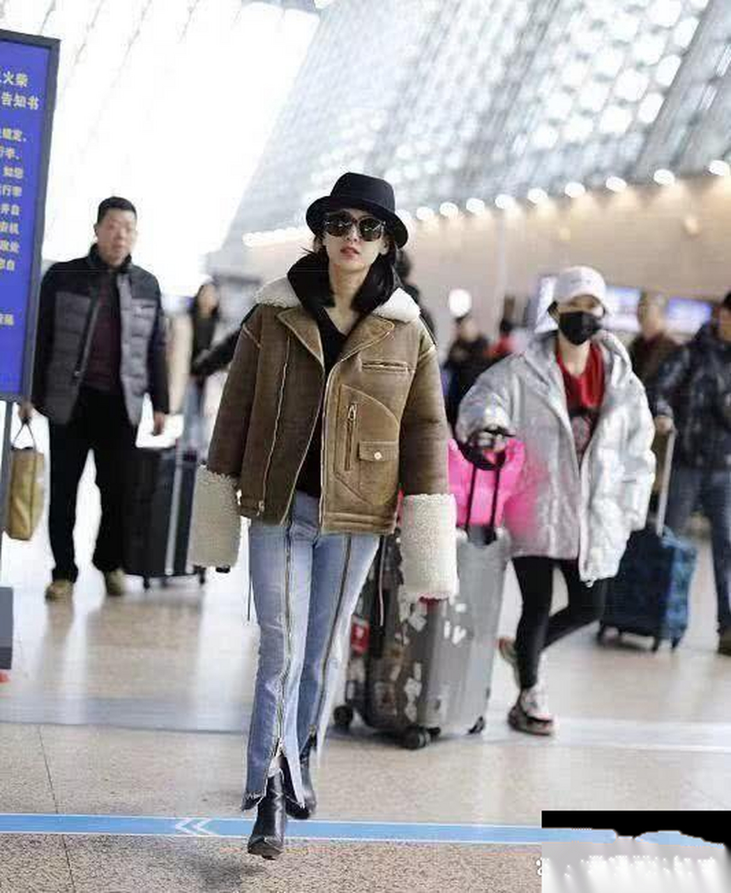 黄圣依穿毛绒外套搭配拉链牛仔裤,再戴上一顶黑色小礼帽