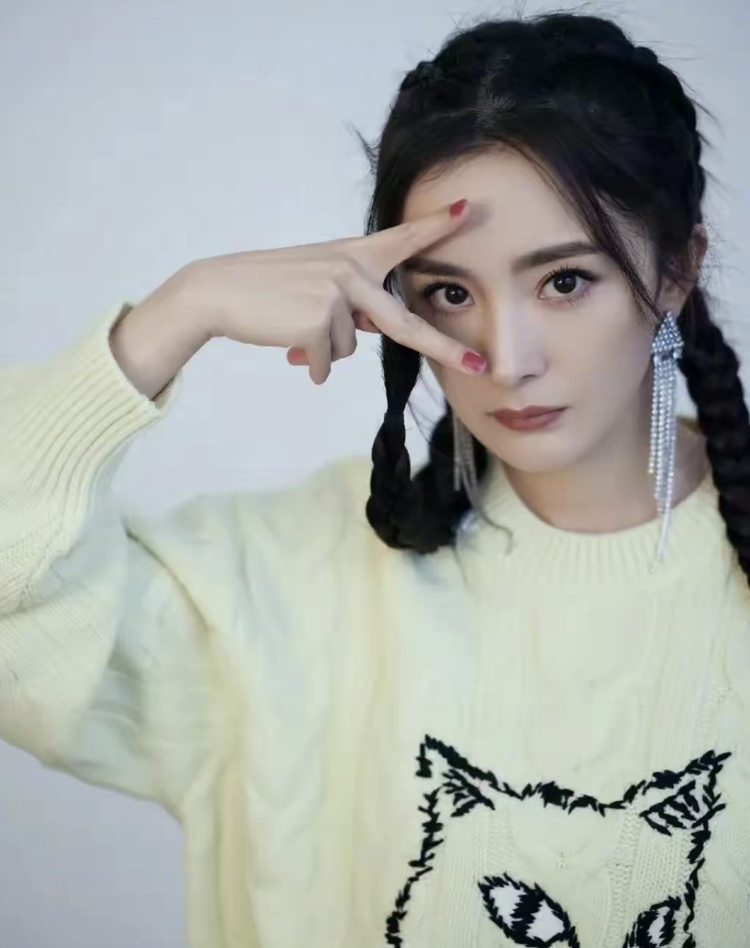 杨幂穿淡黄色毛衣,双麻花辫子搭配黑色皮短裤,甜美俏皮,大长腿吸睛