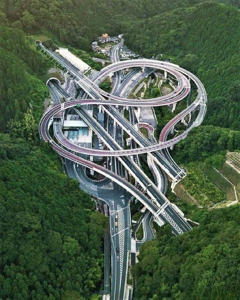 在群山俊岭之中,高速公路的互通蜿蜒盘旋,如舞动的银蛇