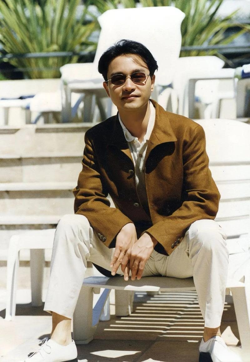 张国荣一组生图,身穿白色服装,外搭黄色上衣,配戴精致墨镜,真的好帅