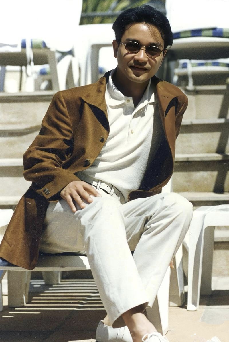 张国荣一组生图,身穿白色服装,外搭黄色上衣,配戴精致墨镜,真的好帅