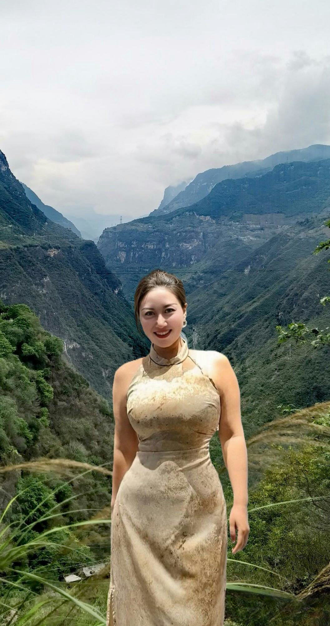 大姐优雅地站在高山之上,远眺着山峦,那连绵不绝的高峰雄伟壮丽,尽收