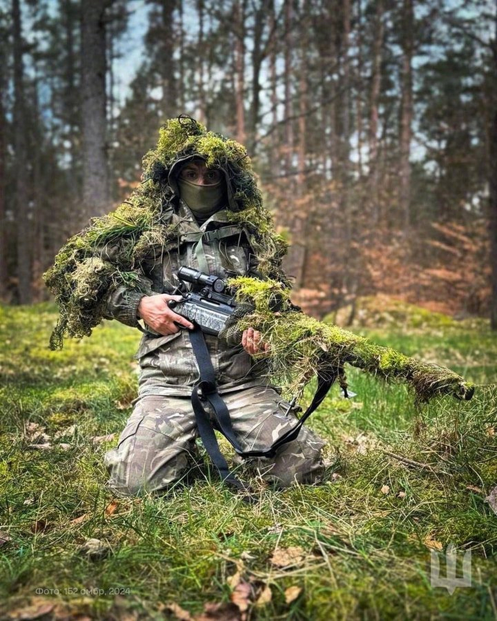 乌克兰武装部队的一名狙击手,正在展示他的吉利服和波