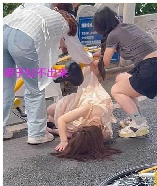 女子穿裙子骑自行车摔倒,裙子绞进车轮扯不出来遭围观:太丢人