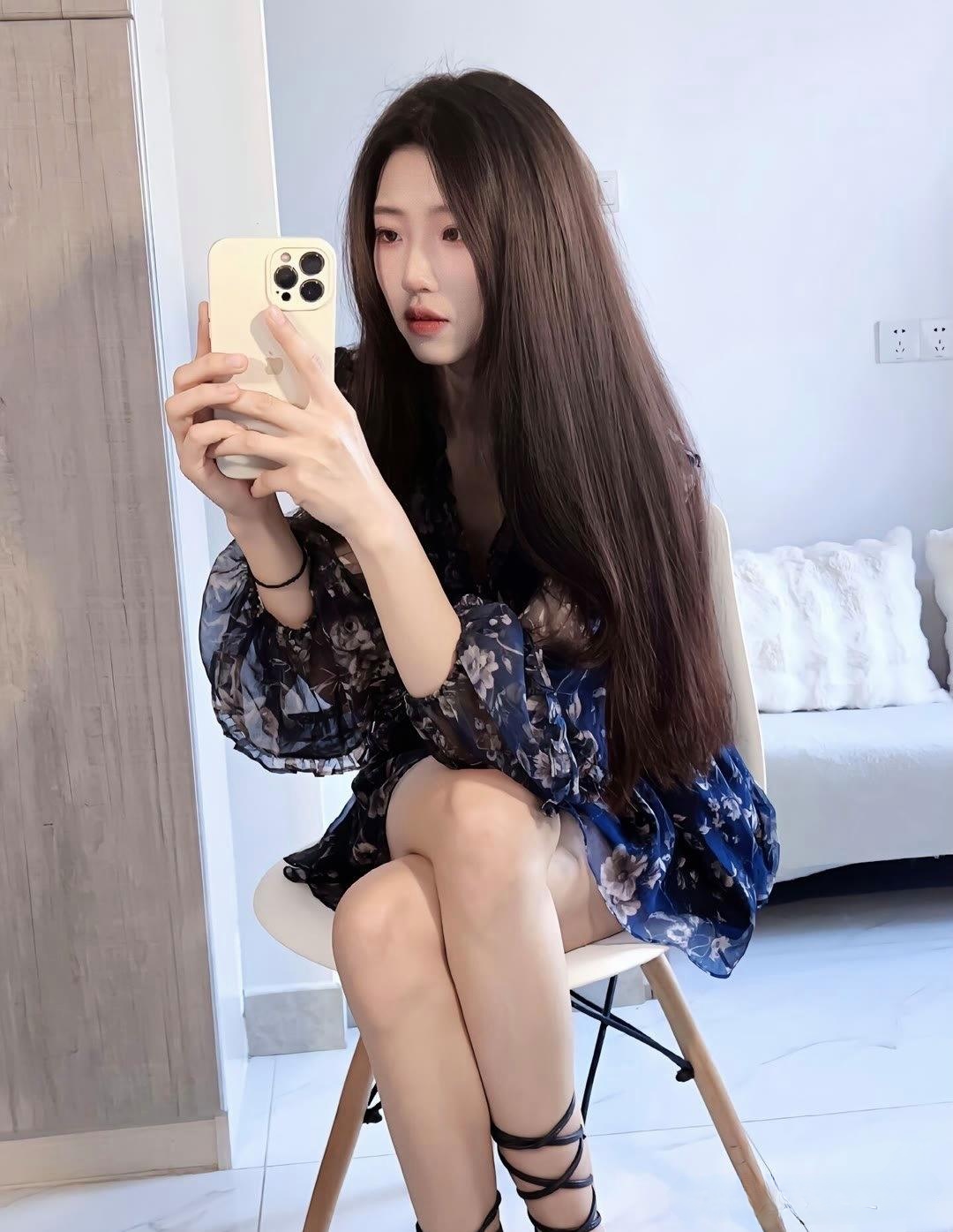 这位美女身穿碎花连衣裙优雅的坐在椅子上摆着各种可爱的姿势自拍着