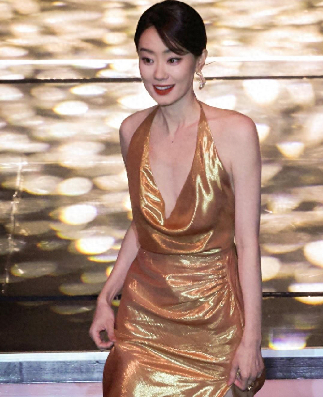 张小斐在某颁奖典礼上身穿金色挂脖低胸礼服,优雅大方,凸显身材曲线和