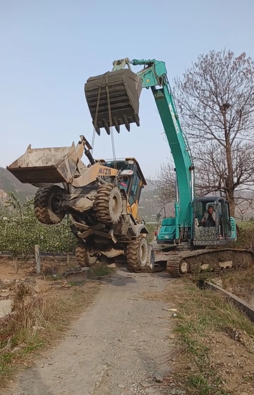 挖掘机的吊力有多大?看,都能像吊车那样把铲车吊进河里干活了!