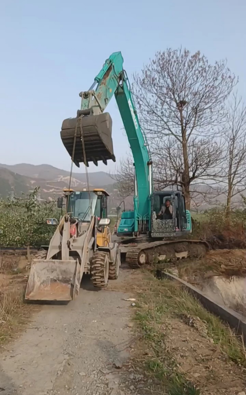 挖掘机的吊力有多大?看,都能像吊车那样把铲车吊进河里干活了!