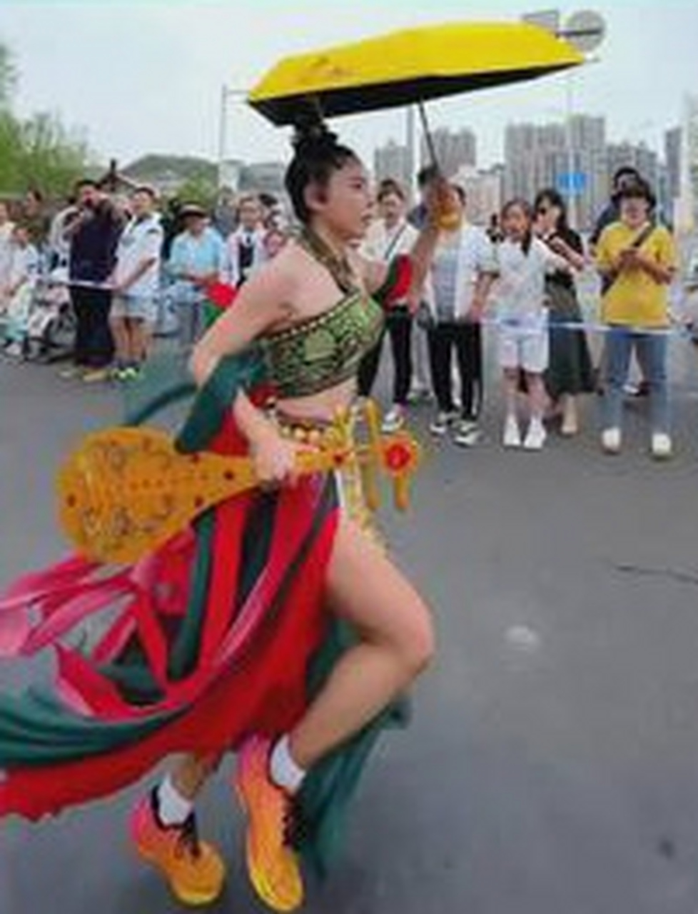 5月26日,兰州"跑马"现场出现了一位"飞天女神",她左手举伞,右手握琵琶