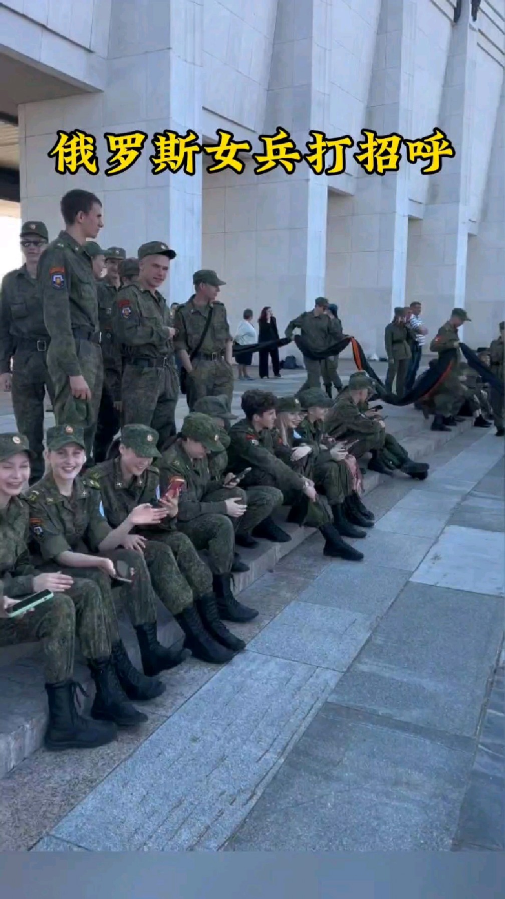 一群俄罗斯女兵热情地用中文向小伙问好,并用某品牌手机对其拍照