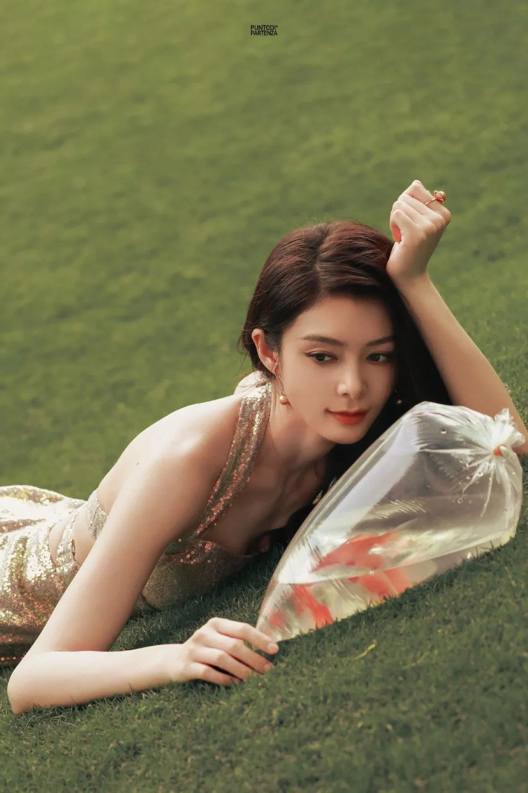 金色的面料与周围的景色形成了鲜明的对比,让傅菁成为了最耀眼的焦点.