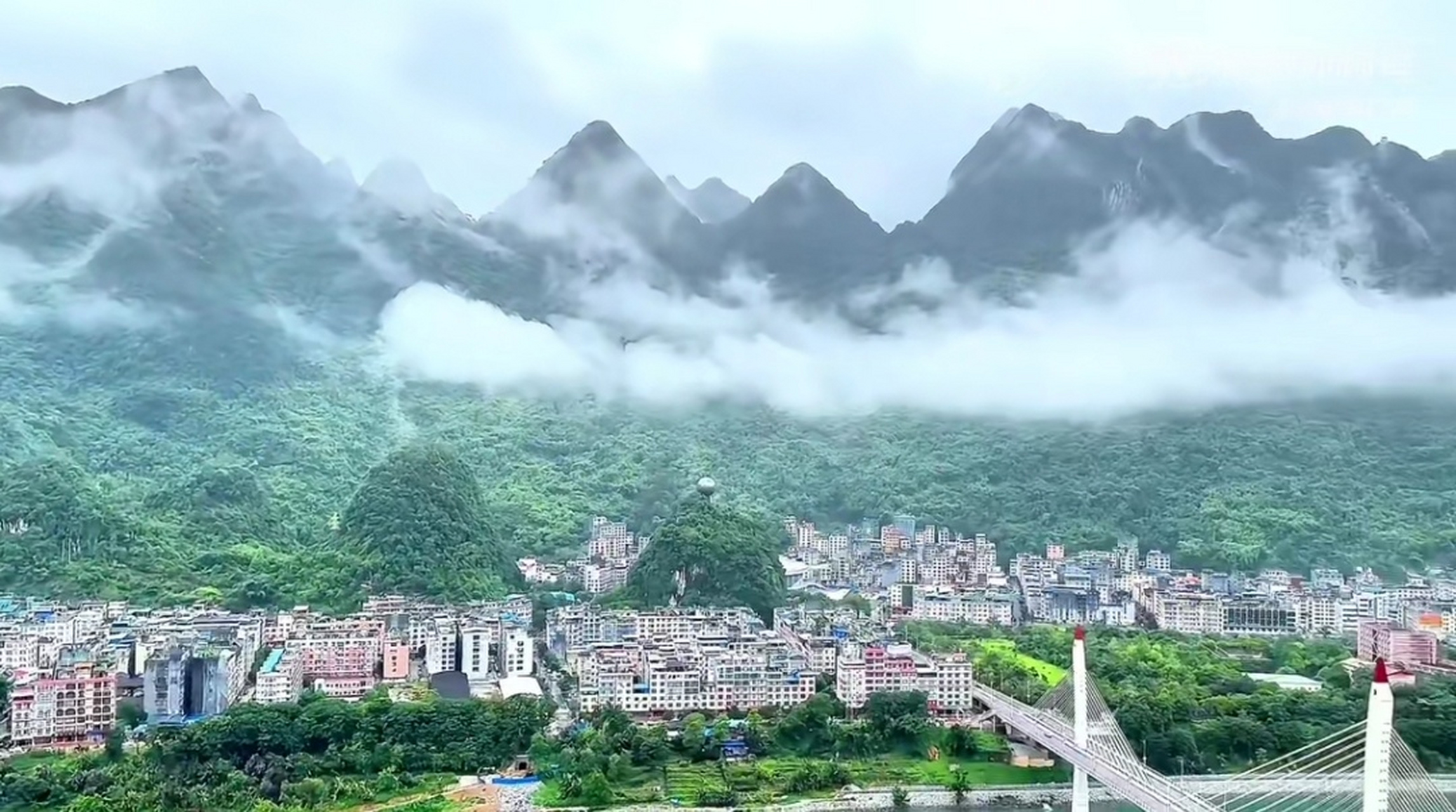 下过雨的广西河池天峨县,远处是被云雾笼罩的山水,山脚下是被青山环绕