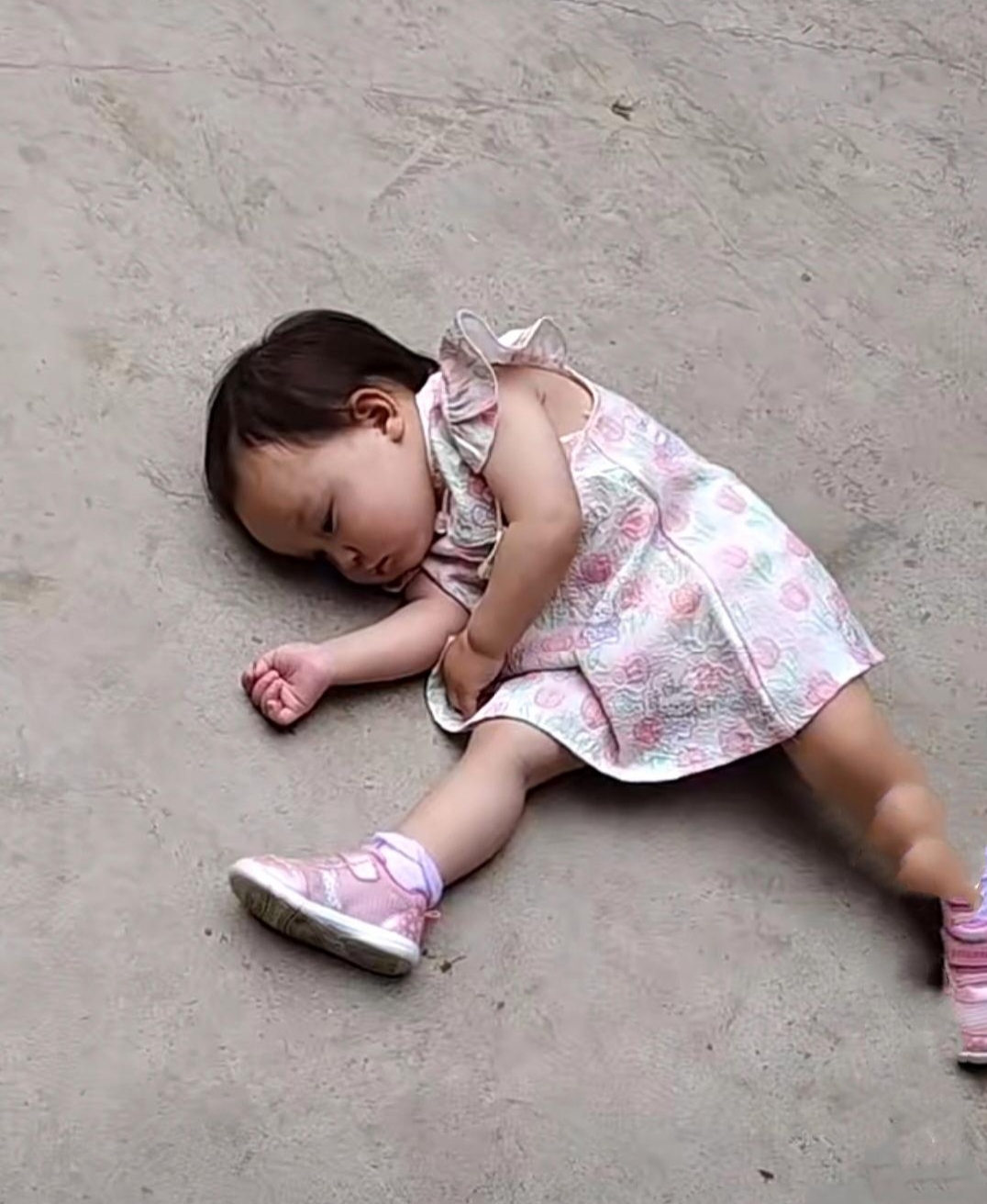 据说这个3岁左右的小女孩,因为妈妈不给她买心仪的布娃娃,她就躺在地