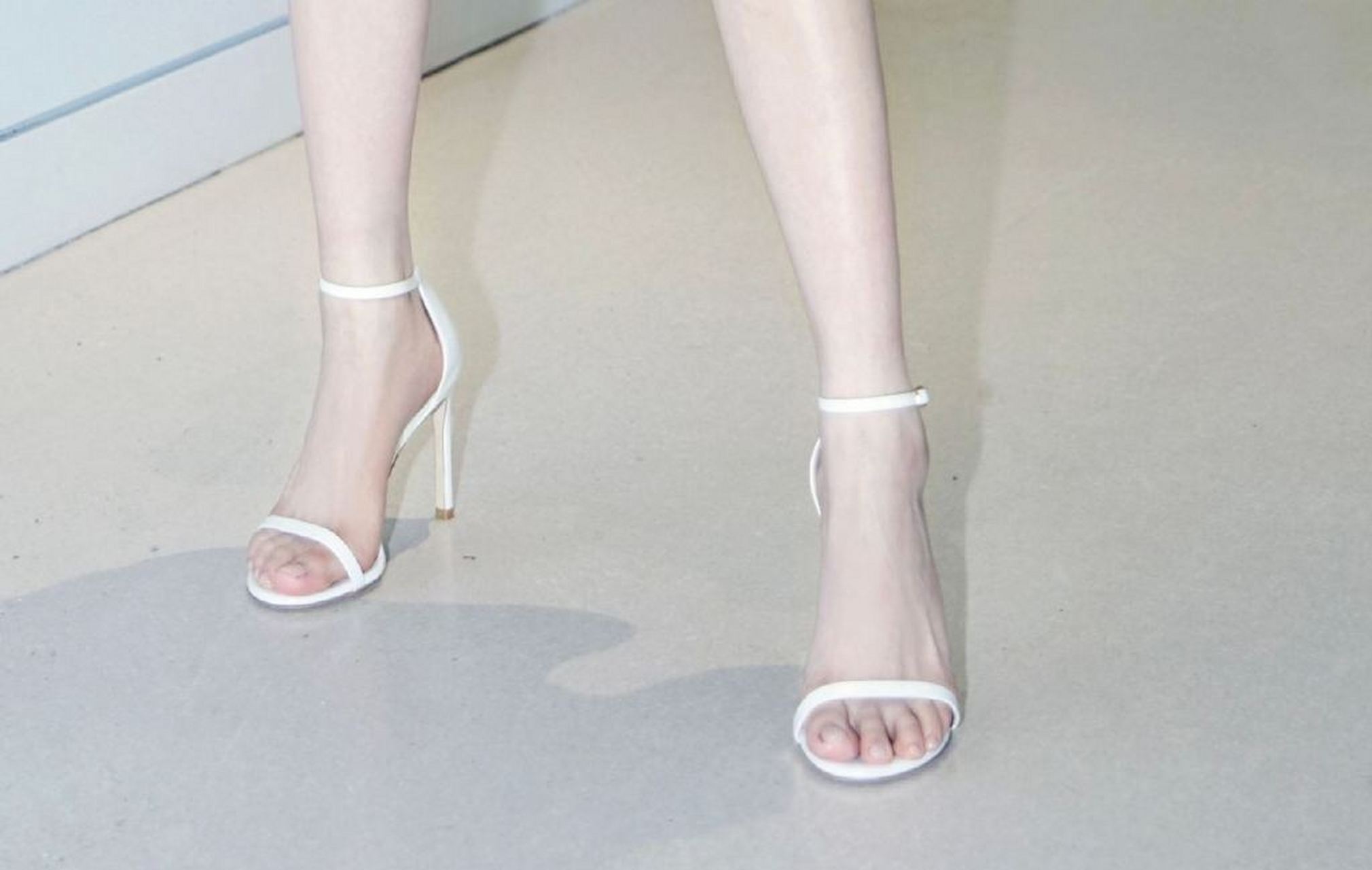 成果的白色一字带高跟鞋,衬托出她的美足,如同花瓣般娇嫩.