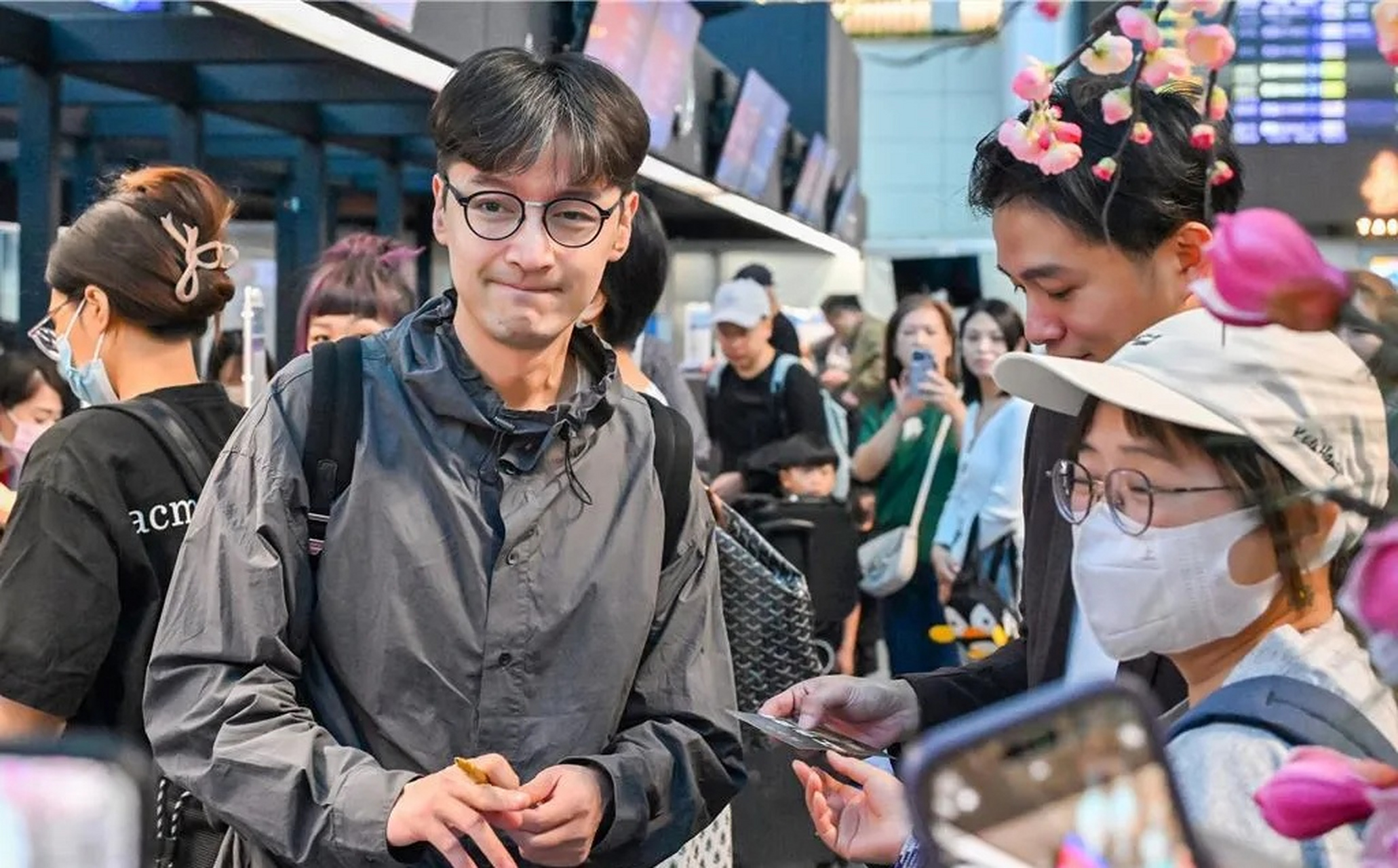 胡歌离开机场返回家中,在机场为粉丝签名,他的打扮令人眼前一亮,充满