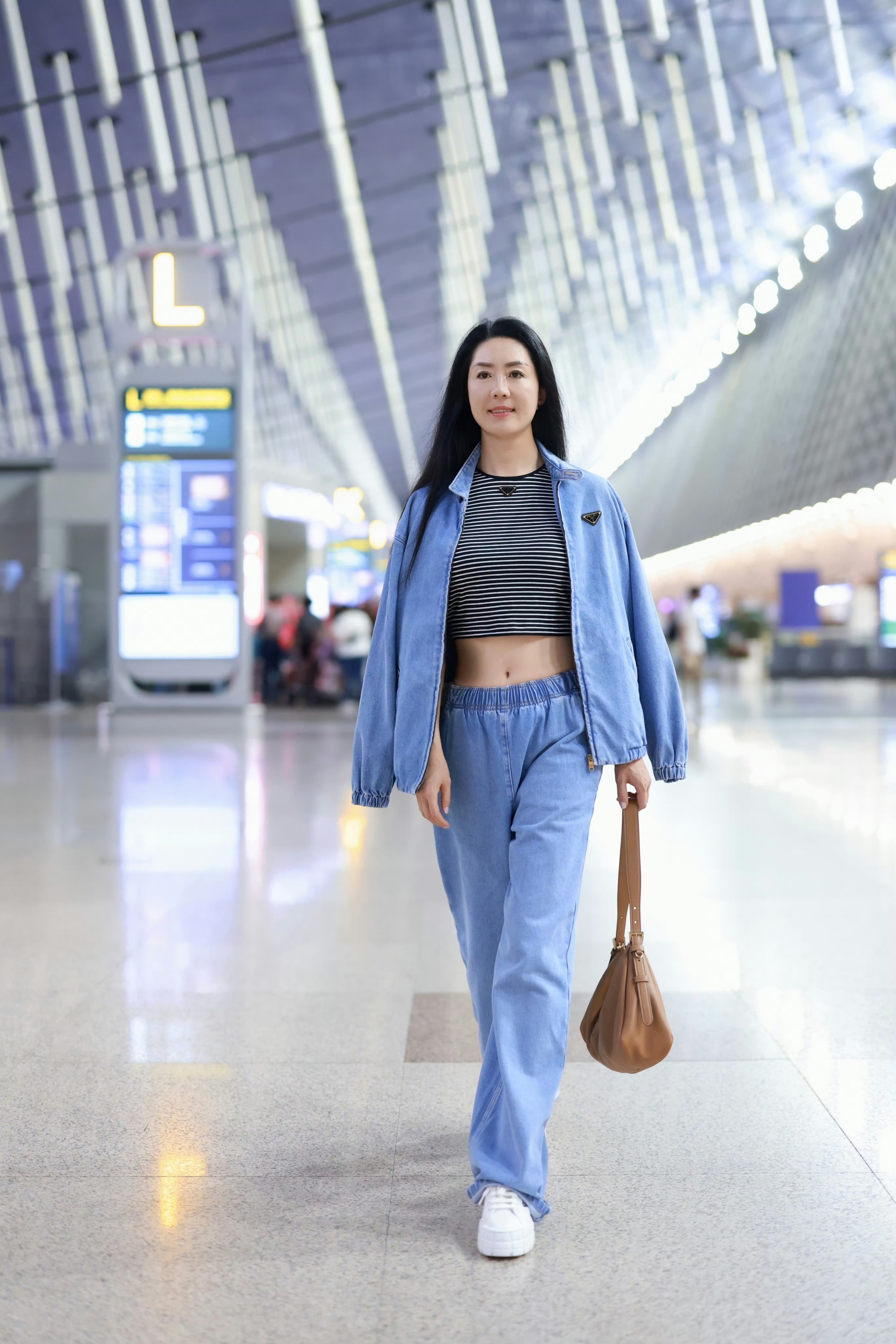 前中国女足队长浦玮身着prada牛仔套装搭配prada aimee手袋现身机场