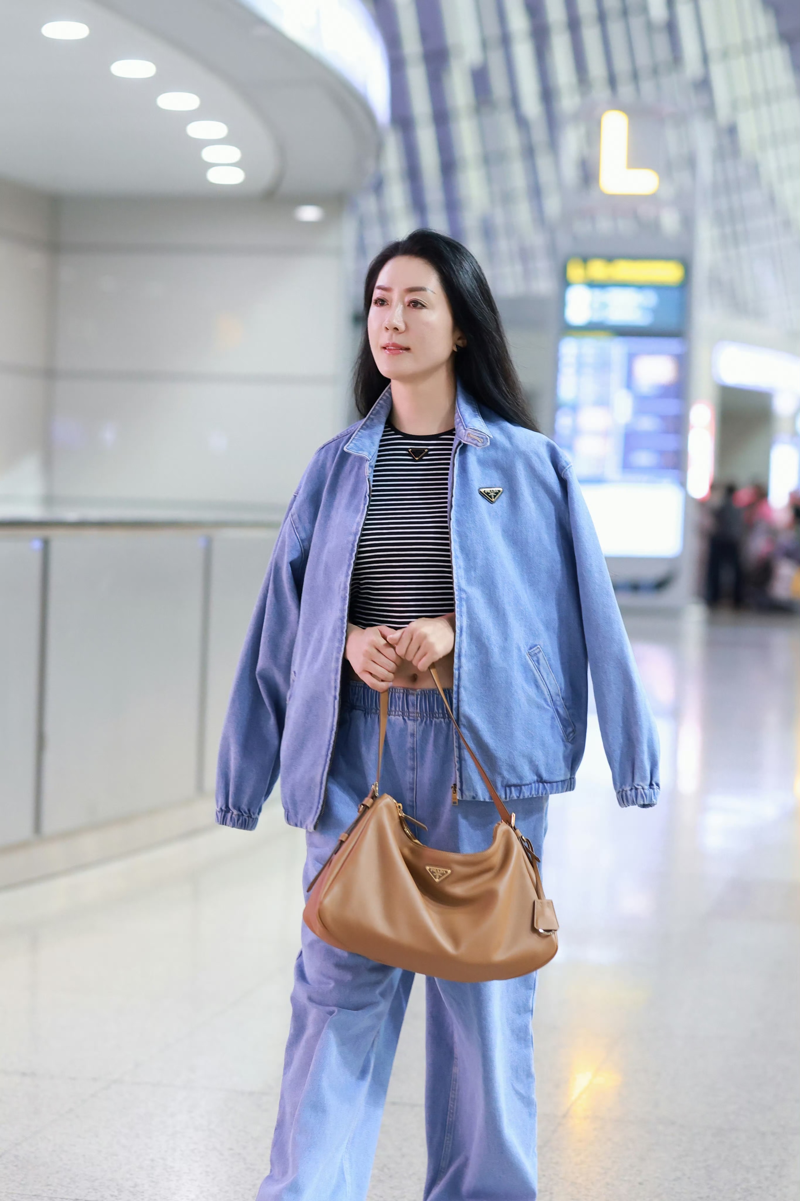 前中国女足队长浦玮身着prada牛仔套装搭配prada aimee手袋现身机场