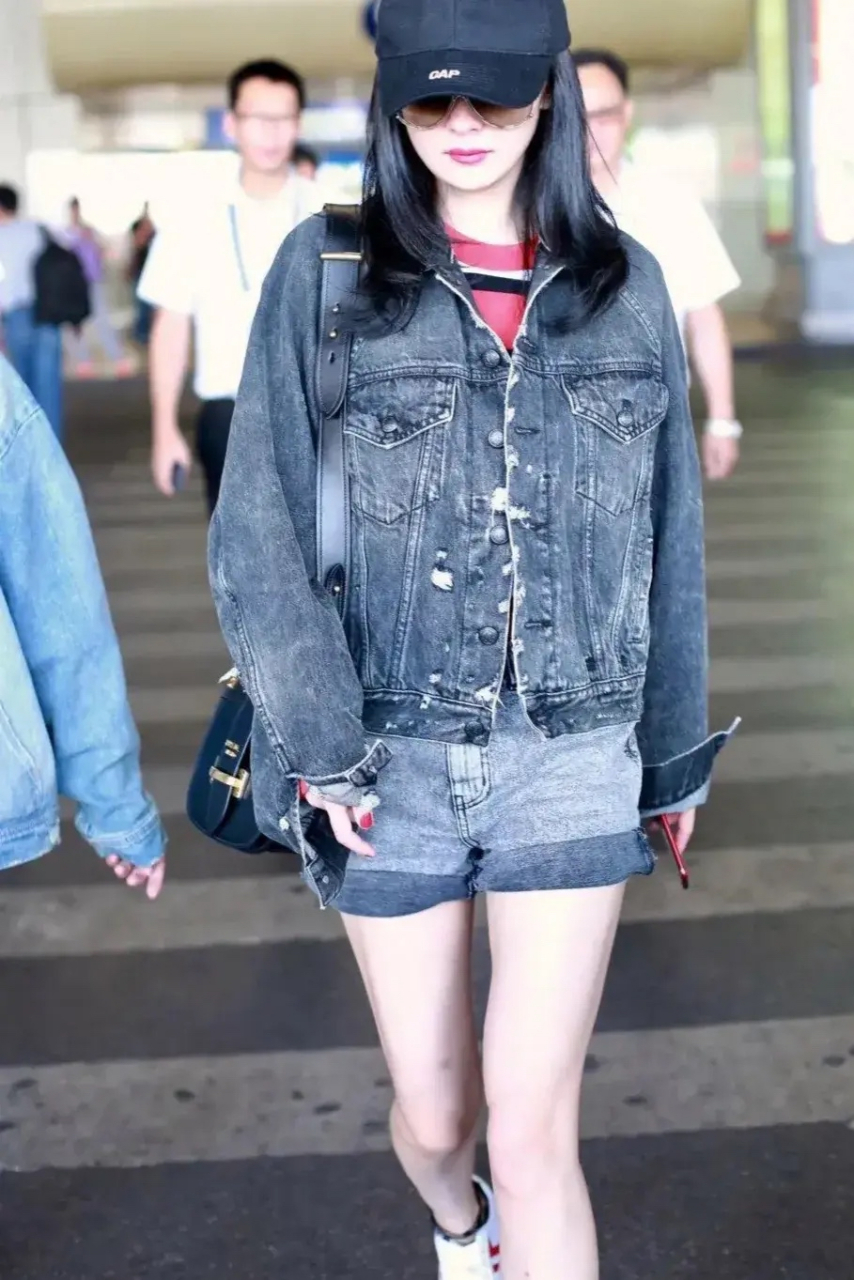 杨幂低调现身机场,戴灰色棒球帽身穿灰色牛仔套装搭白色板鞋轻松穿出