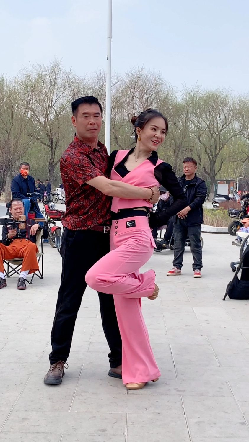 哎呀,场上跳舞的小媳妇真漂亮,引来粉丝大叔,手架俩手机来拍摄