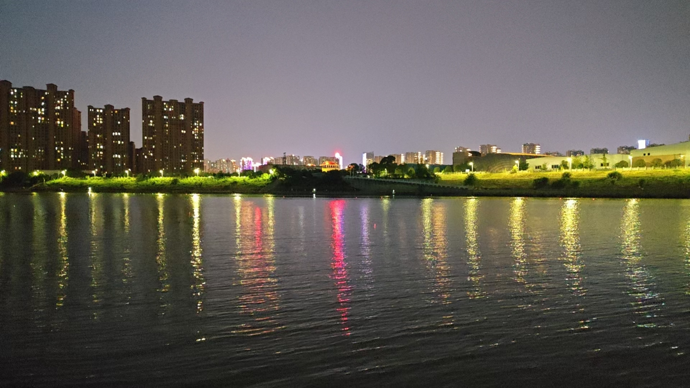 夜晚的江边,霓虹灯洒在江上,微风拂过.